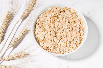 Oatmeal and ears of wheat on a white background. healthy eating. Minimalism