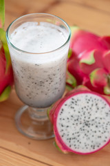 Dragon fruit smoothie on wooden table.