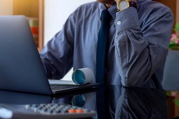 Businessman work on laptop computer with checkbook and calculator on the desk. Business economy...