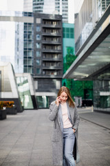 business woman talking on the phone in the background of an office building