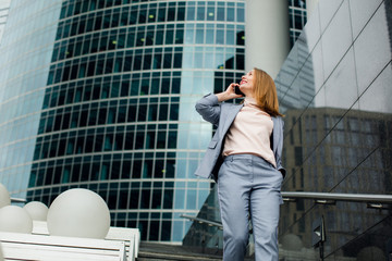 business woman talking on the phone in the background of an office building