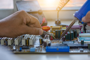 Closeup image of technician man hand using soldering to repair hardware computer.Maintenance computer service and support concept.