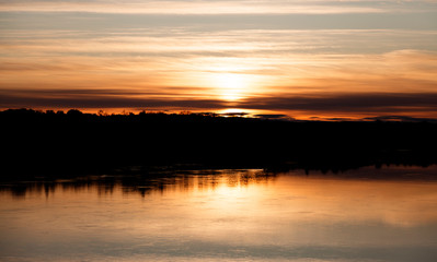 sunset at Umea river in early autumn, in the background you can see the vegetation on the other side of the water