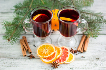christmas hot mulled wine with cinnamon orange and anise on white wooden background