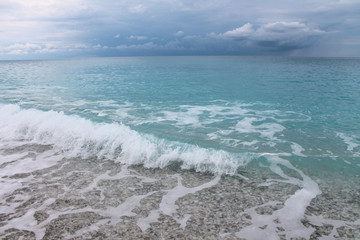 Turquoise ocean with dark clouds