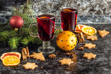 Christmas mulled wine with ginger biscuits orange cinnamon clove anise and fir tree on the dark...