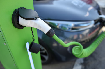 Electrical car connected through a charging cable to a charge station.