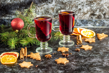 Christmas mulled wine with ginger biscuits orange cinnamon clove anise and fir tree on the dark...