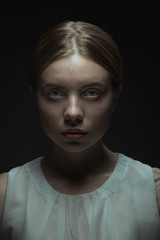 Blonde woman in white t-shirt with dramatic light.