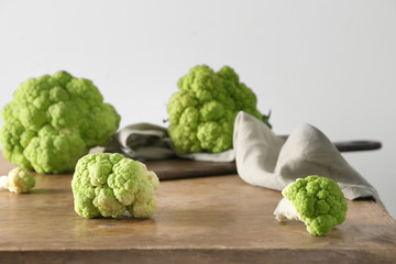 Tasty fresh cauliflower cabbage on wooden table against light background