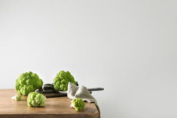 Tasty fresh cauliflower cabbage on wooden table against light background