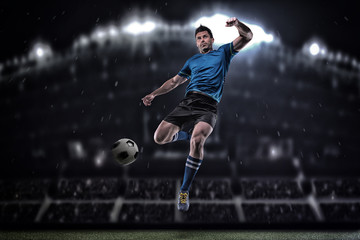 Fototapeta na wymiar Soccer player in action on a dark background
