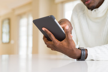 Close up of african business man using touchpad tablet, working sitting on a desk