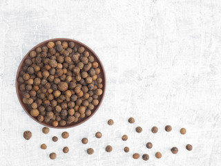 Spices and herbs help maintain good health and improve appetite, top view on white concrete background. Allspice. Modern apothecary, naturopathy and ayurveda concept.