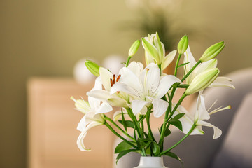Beautiful lily flowers in vase in room