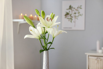 Beautiful lily flowers in vase in room