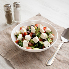 Homemade Shepards salad in a white bowl, side view. Closeup.