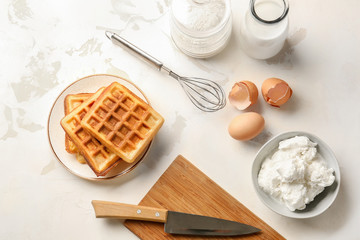 Composition with tasty waffles and ingredients on table