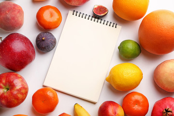 Notebook with fresh fruits on white background. Diet concept
