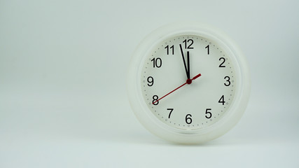 Clock beginning of time 11.57 am or pm, on white background, Copy space for your text, Time concept.