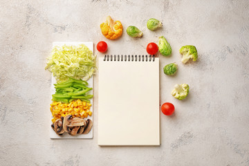 Notebook with healthy products on light background. Diet concept
