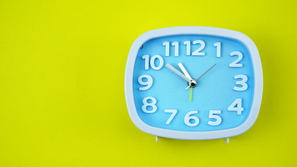 Blue Alarm clock face beginning of time 10.50 on Yellow background, Copy space for your text, Time concept..