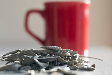 green tea leafs and a cup of tea