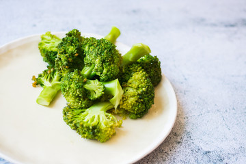 Cooked or steamed broccoli inflorescence, sprouts on plate.