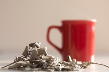 green tea leafs and a cup of tea
