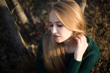 Naklejka premium Autumn atmospheric portrait of an attractive girl with long hair in a green jacket.