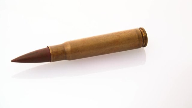 Close macro shot of a rifle bullet shell rotating.