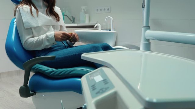 brunette woman patient looks nervous while sitting in the dentist's office
