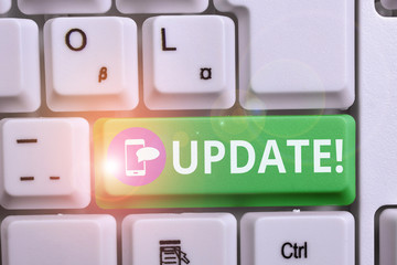Writing note showing UPDATE. Business concept for make something more modern or up to date like software program Keyboard with note paper on white background key copy space