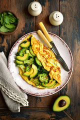 Omelette stuffed with green vegetables : broccoli, avocado and baby spinach.Top view with copy space.
