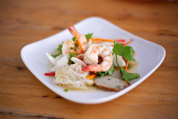 Spicy salad seafood with fresh shrimps, squid and mixed vegetables, Healthy asian food for diet lifestyle.