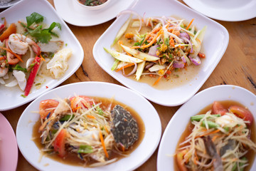 Closeup eggs crab spicy salad papaya, Som Tum and other food in Thai local restaurant.