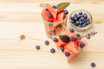 Fresh summer fruit dessert. Sweet watermelon and blueberry, purple basil leaves