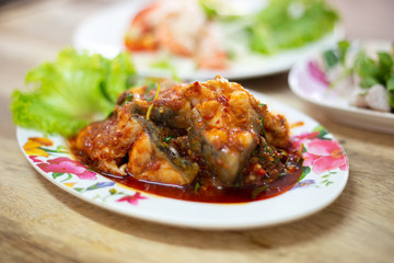 Stir-fried deep fried fish (Asian redtail catfish) with red curry paste. Thai healthy asian food from fish cooked.