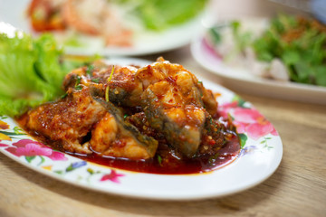 Stir-fried deep fried fish (Asian redtail catfish) with red curry paste. Thai healthy asian food from fish cooked.