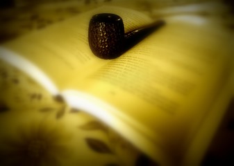 an open book and a pipe