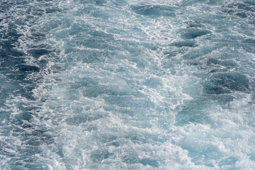 Splashing drops of blue sea water during the movement of the ship.