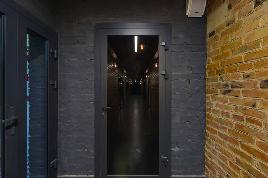 Door with black glass and gray painted brick wall.