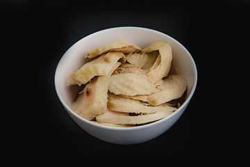 Thinly sliced ​​boiled chicken on black background