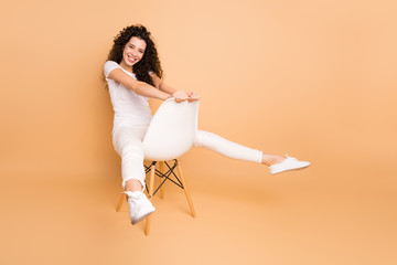 Full length photo of amazing lady sitting comfortable chair between legs good playful mood wear...