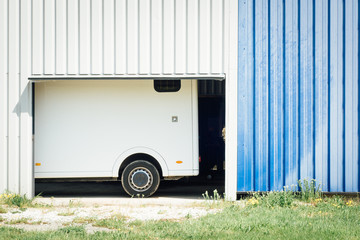 une remorque garée dans un garage avec des lignes verticales et une porte ouverte