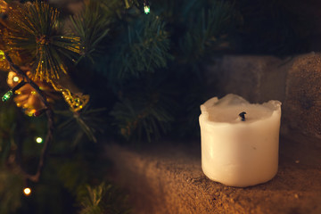 White extinct candle near to Christmas tree. Close-up.