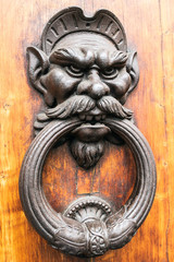 Antique knocker in the shape of an angry gnome face