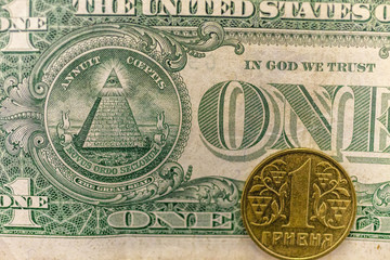 One hryvnia coin on 1 dollar note
