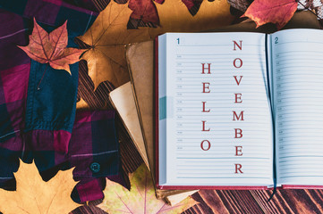 Hello November, the inscription on the diary, yellow maple leaves, warm men's shirt.