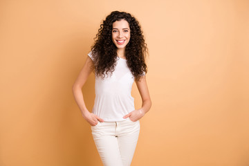 Obraz premium Photo of amazing business lady holding hands in pockets self-confident person wear white casual t-shirt trousers clothes isolated beige pastel color background
